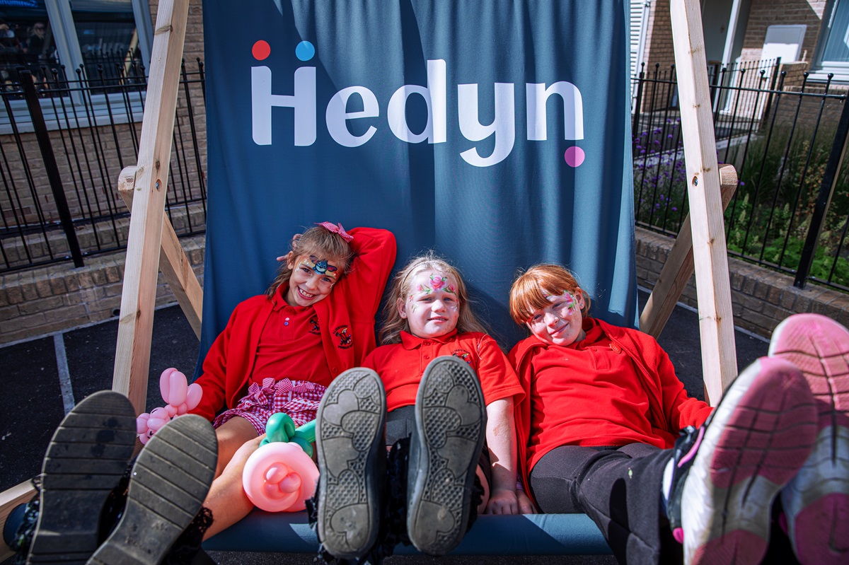 Pupils from Lliswerry Primary School sat on the big Hedyn deck chair enjoy the opening celebration event of Long Meadow Court.