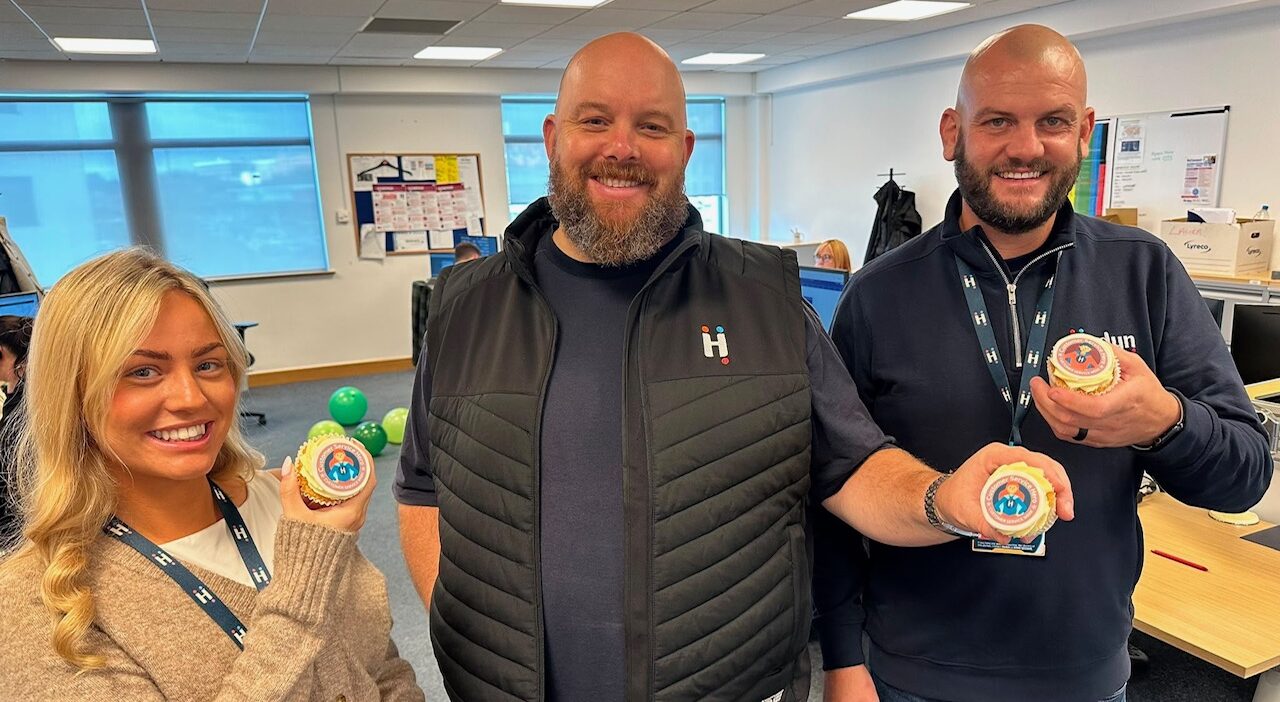 Three Hedyn staff pose with branded cupcakes